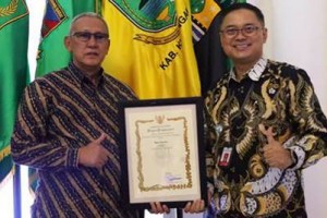 Bupati Kuningan dan Kadiskominfo Kuningan berfoto bersama usai menerima penghargaan.